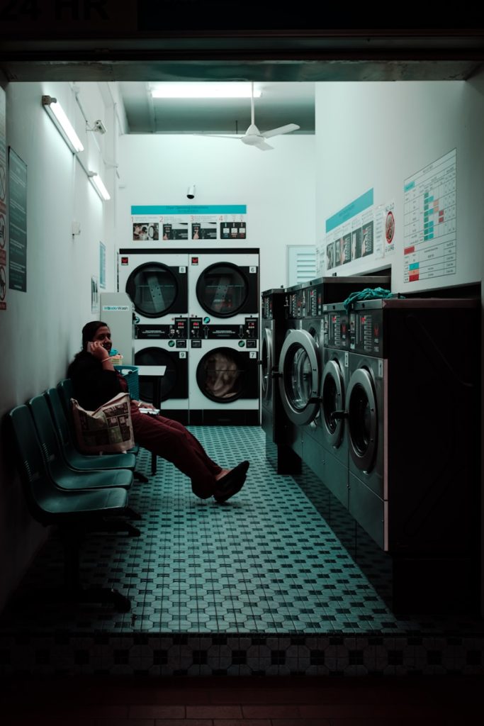 Wash Your Clothes, woman sitting inside laundry shop